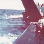 Erix Santana, EN3(SS), on the bow.  preparing to send hose over for pumping.
  
Note Stickleback sailors around After Battery hatch and on the bridge